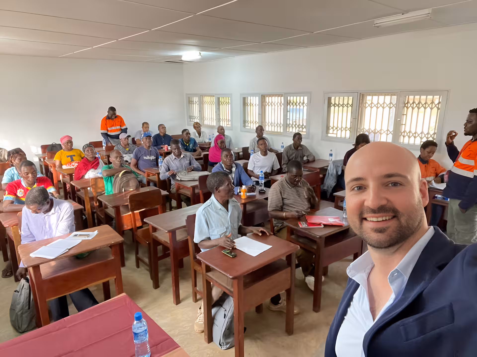 Thomas Gaultier with community members gathered in the room where the mediation session is about to begin, Cabo Delgado, Mozambique